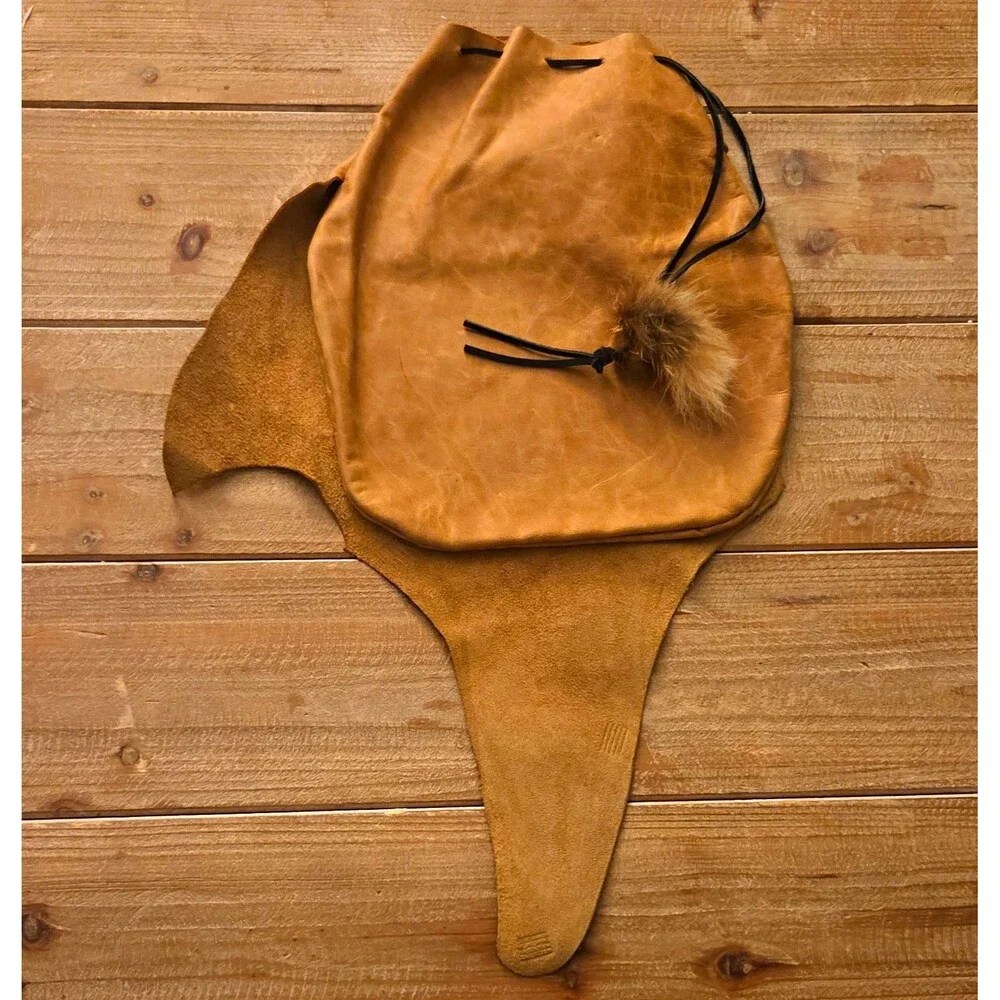 Handcrafted tan leather drawstring pouch featuring a soft fur pom-pom